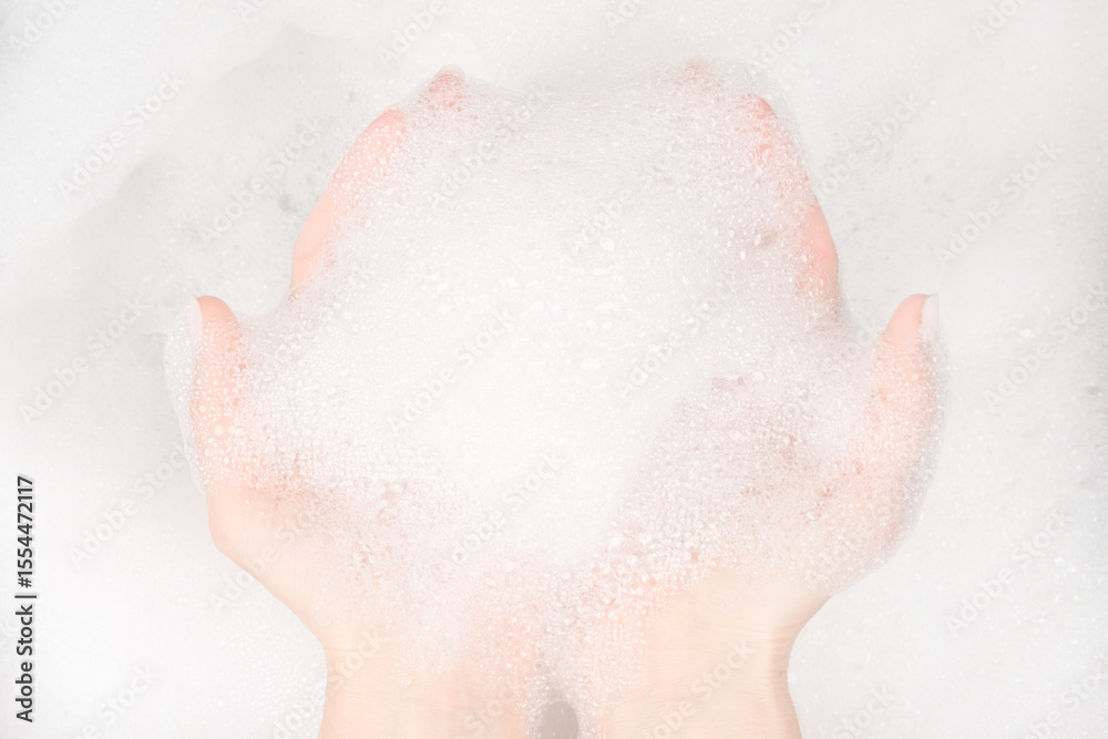 Fototapeta premium Female hands in foam close-up. girl's hands in soap foam. washing, cleaning, washing dishes