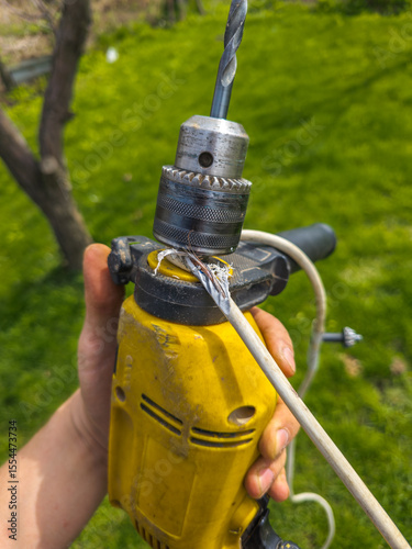 Damaged electrical wire wrapped around an old electric drill