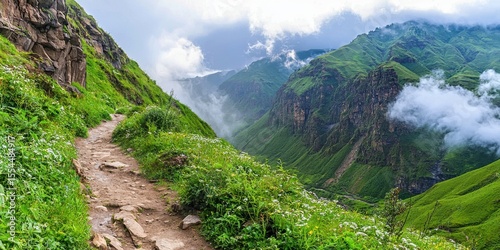 A scenic mountain trail winds through lush green hills under a cloudy sky, offering breathtaking views of deep valleys and rocky cliffs.