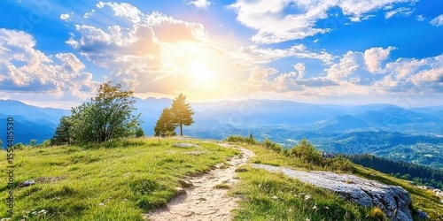 A bright sunrise over a grassy hilltop with scattered trees and a winding path, overlooking distant blue mountains beneath a partly cloudy sky.