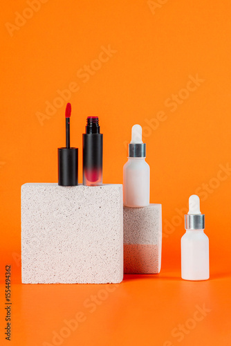 Mockup of black blank thin tube - mascara, lip gloss, gel, eyeliner, oil, etc. Cosmetic package with stylish props on orange background.