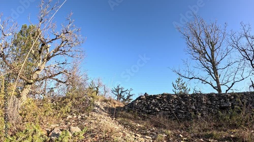 Man running while pushing unicycle uphill rocky terrain Occitanie