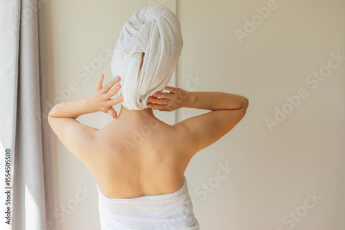 Wallpaper Mural Cheerful young woman wrapped in a white towel smiling with eyes closed, enjoying a peaceful self-care moment at home. Natural beauty, relaxation, and skincare routine concept. Torontodigital.ca