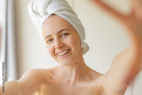Wallpaper Mural Cheerful young woman wrapped in a white towel smiling with eyes closed, enjoying a peaceful self-care moment at home. Natural beauty, relaxation, and skincare routine concept. Torontodigital.ca