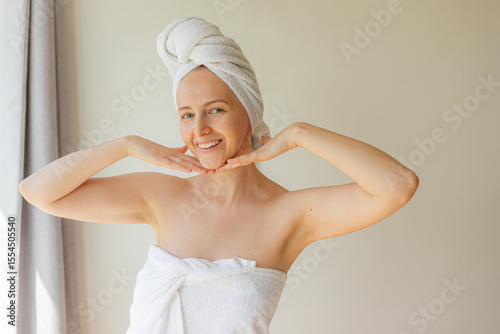 Wallpaper Mural Cheerful young woman wrapped in a white towel smiling with eyes closed, enjoying a peaceful self-care moment at home. Natural beauty, relaxation, and skincare routine concept. Torontodigital.ca