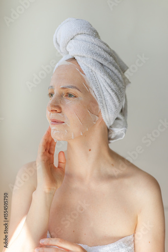 Wallpaper Mural Young woman relaxing at home with a hydrating facial sheet mask.  kincare routine, beauty treatment, and wellness lifestyle concept. Torontodigital.ca