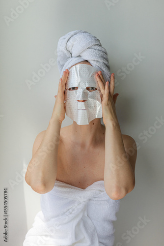Wallpaper Mural Young woman relaxing at home with a hydrating facial sheet mask.  kincare routine, beauty treatment, and wellness lifestyle concept. Torontodigital.ca