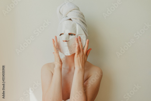 Wallpaper Mural Young woman relaxing at home with a hydrating facial sheet mask.  kincare routine, beauty treatment, and wellness lifestyle concept. Torontodigital.ca