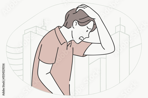 Frustrated young man grabs his head, overwhelmed by stress and uncertainty.