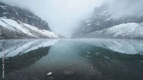 Fototapeta Naklejka Na Ścianę i Meble -  Serene Mountain Lake Reflection in Misty Peaks