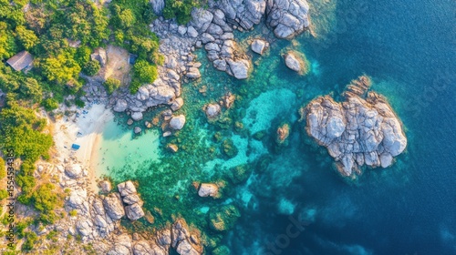 Aerial View of Rocky Coastal Cove with Clear Turquoise Water and Green Forest