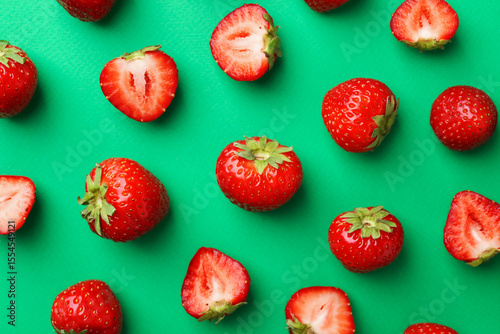 Quadro su tela Fresh ripe strawberries on green background, flat lay