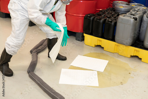 Hazmat Worker Handling Absorbent Boom for Industrial Spill
