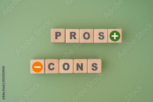 Pros and Cons word on wooden cube blocks with green color background