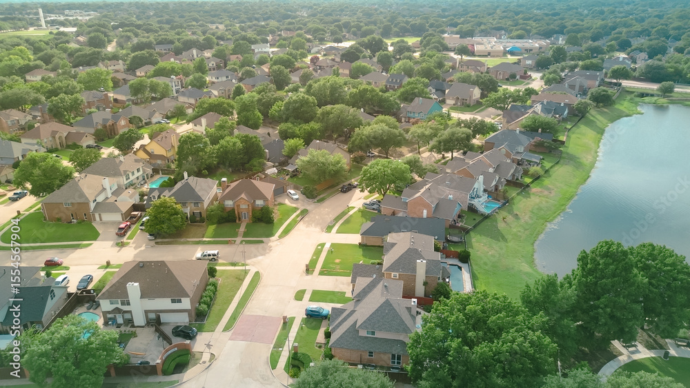 Fototapeta premium Waterfront upscale suburban neighborhood near Rheudasil Park in Flower Mound, suburbs Dallas Texas, lakeside two-story single-family homes with large green backyards, swimming pools, lush trees