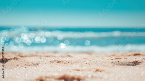 Fototapeta Naklejka Na Ścianę i Meble -  Sandy beach meets a serene turquoise sea, sunlight creating shimmering reflections on the water's surface for a relaxing summer vacation vibe.