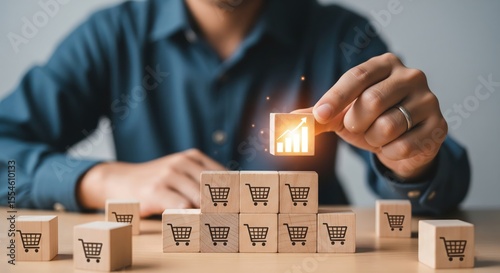Male hand putting cube with icon growing graph and shopping cart symbol. sale volume increase make business grow.