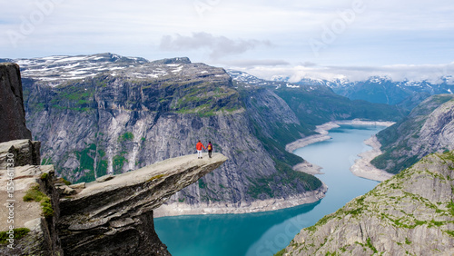Εκτύπωση καμβά Majestic cliffside view in Norway with adventurers overlooking breathtaking fjor