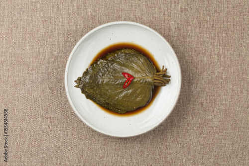   A pickled food made by soaking perilla leaves in salt water or soybean paste.
