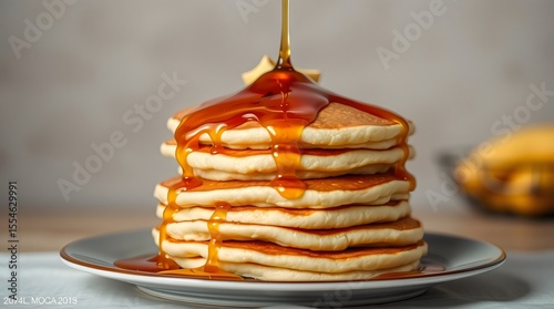 Hot, fluffy pancakes stacked high with syrup and steam rising above