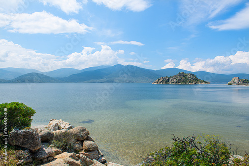 Fototapeta Naklejka Na Ścianę i Meble -  Spectacular Bafa Lake view in sunny and cloudy weather. Reflections in Bafa Lake. View of Bafa Lake Nature Park in Türkiye.