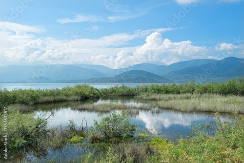 Fototapeta Naklejka Na Ścianę i Meble -  Spectacular Bafa Lake view in sunny and cloudy weather. Reflections in Bafa Lake. View of Bafa Lake Nature Park in Türkiye.