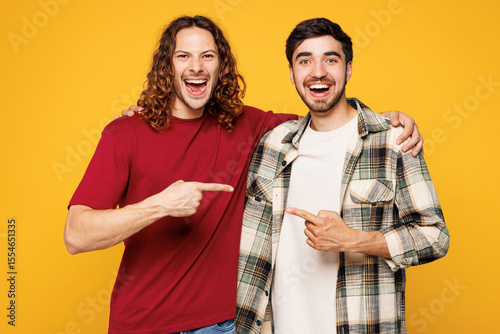 Cuadro en lienzo Young smiling two friends buddies men they wear casual clothes together point in