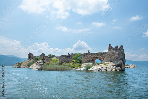 Fototapeta Naklejka Na Ścianę i Meble -  Bafa Lake in sunny weather. Historical castle and city wall ruins in Bafa Lake. Magnificent Bafa Lake view. Muğla, Türkiye.