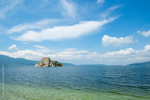 Fototapeta Naklejka Na Ścianę i Meble -  Bafa Lake in sunny weather. Historical castle and city wall ruins in Bafa Lake. Magnificent Bafa Lake view. Muğla, Türkiye.