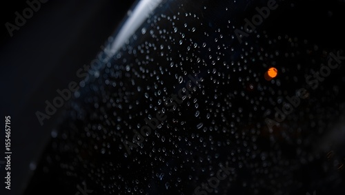 Water Droplets Forming Trails on a Dark Vertical Window