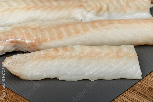 Canvas Print Fresh fish, cod loin on a chopping board close-up