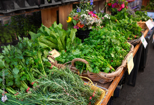 Fresh cut bunches of herbs to include rosemary and parsley in baskets at a local farmer's market