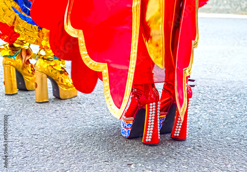 Close-up of the shoes of the participants of the street costume parade. Bright details of the costumes, decorative shoes, elements of accessories, everything in motion and festive atmosphere