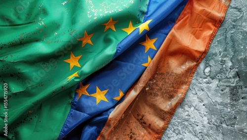 Close up of the flag with stars and green, blue white colour on one side next to irish flag with three colours and orange in centre