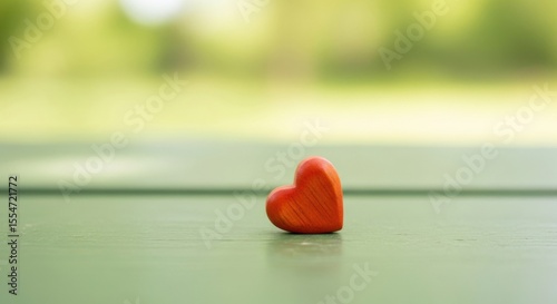 Single Heart Shape Object on Green Surface with Blurred Background