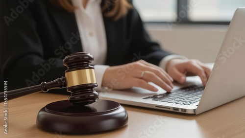 Lawyer Working on a Laptop with Gavel on Table During Meeting