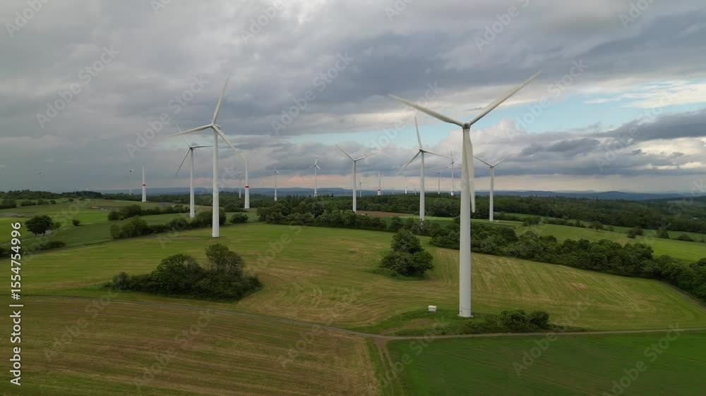 wind farm featuring numerous white turbines across rolling green fields under a cloudy sky wind farm featuring numerous white turbines across rolling green fields under a cloudy sky