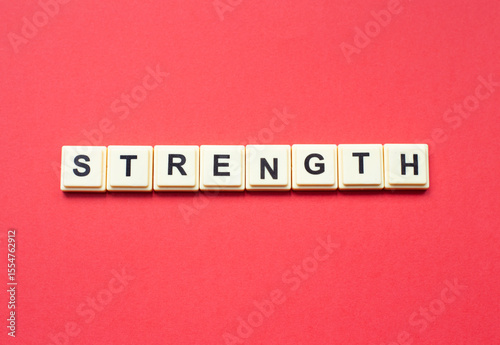 Strength word with alphabet cubes isolated on red background
