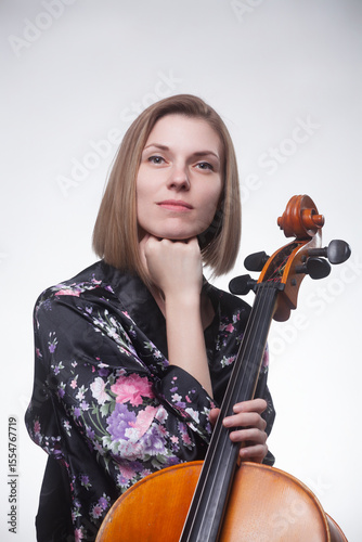 Woman holding cello in floral robe