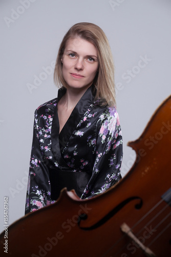Woman in floral robe with cello.
