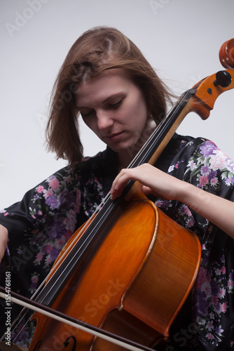 Woman playing cello, close-up, with bow and instrument.
