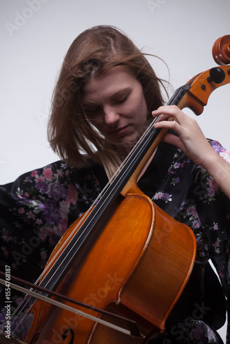 Woman playing cello, close-up, studio shot.