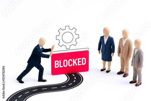 Miniature scene depicting person business suit pushing against large BLOCKED sign with gear icon above, symbolizing concept of obstacle or restriction professional or technological environment