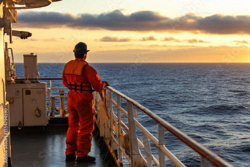 Crew member observes sunset over the ocean from ship Generative AI