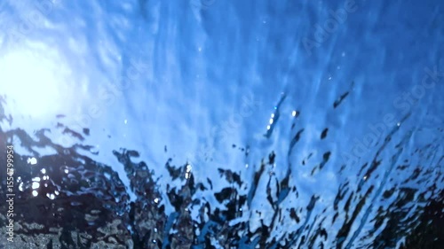 Background and texture of moving transparent water on blue sky.
