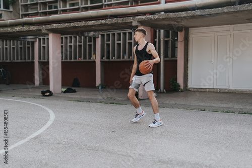 Photos Friends playing basketball at an old neighborhood court, emphasizing camaraderie, athleticism, and the nostalgic charm of urban play areas