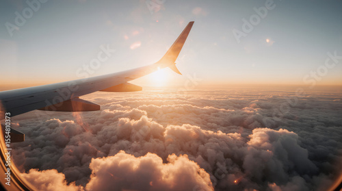 Airplane flying low over foggy mountains, view from plane window of plane wing and sky sunrise