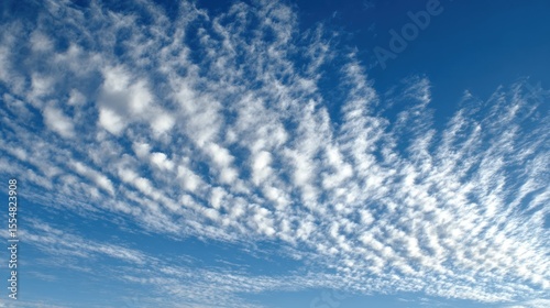 Blue sky with altocumulus clouds creating a textured cloudscape pattern.