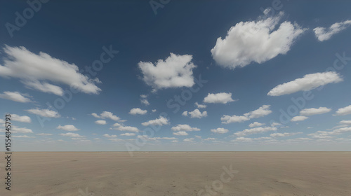 Wide open expanse of light beige desert under a partly cloudy, vibrant blue sky