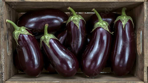 Fresh eggplants in wooden crate. shiny dark purple vegetable in rustic setting